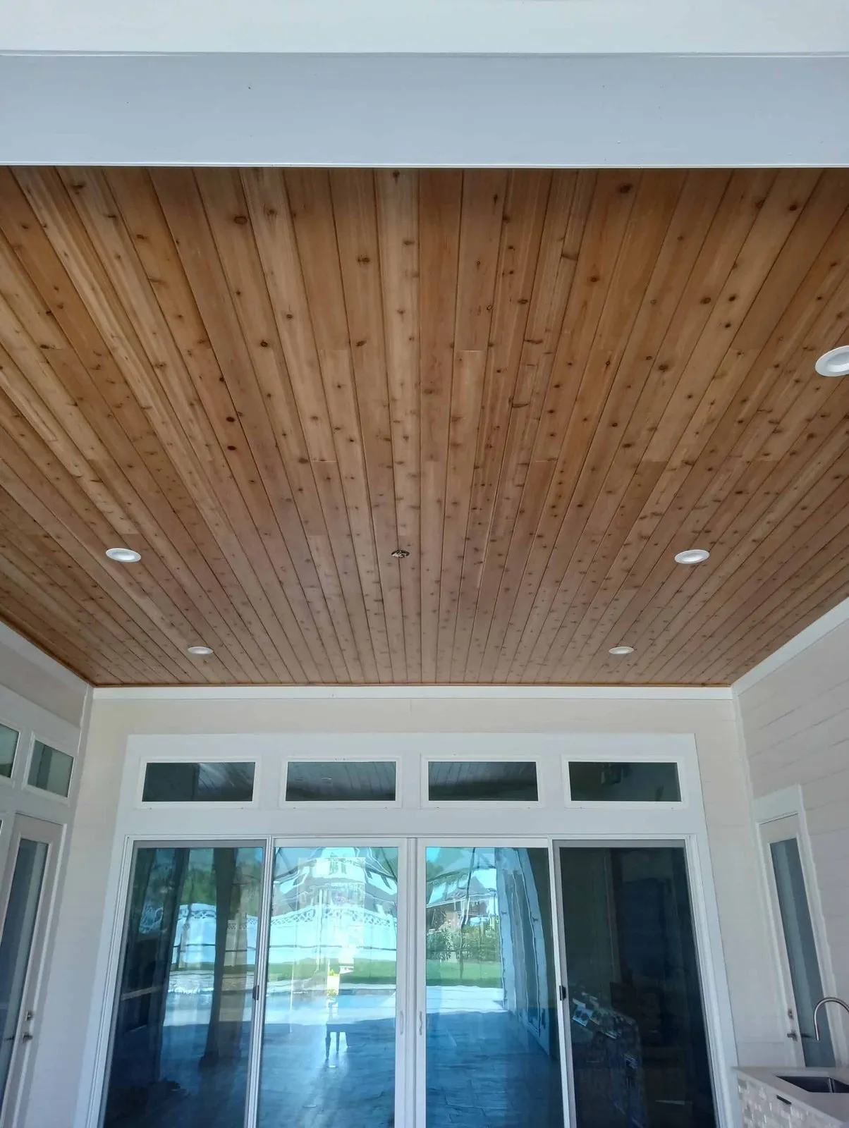 Wood plank accent ceiling above a wall of sliding glass doors