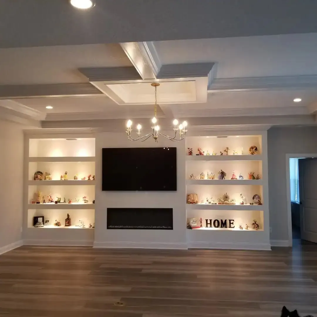 Built-in niches with integrated LED lighting around a TV and electric fireplace