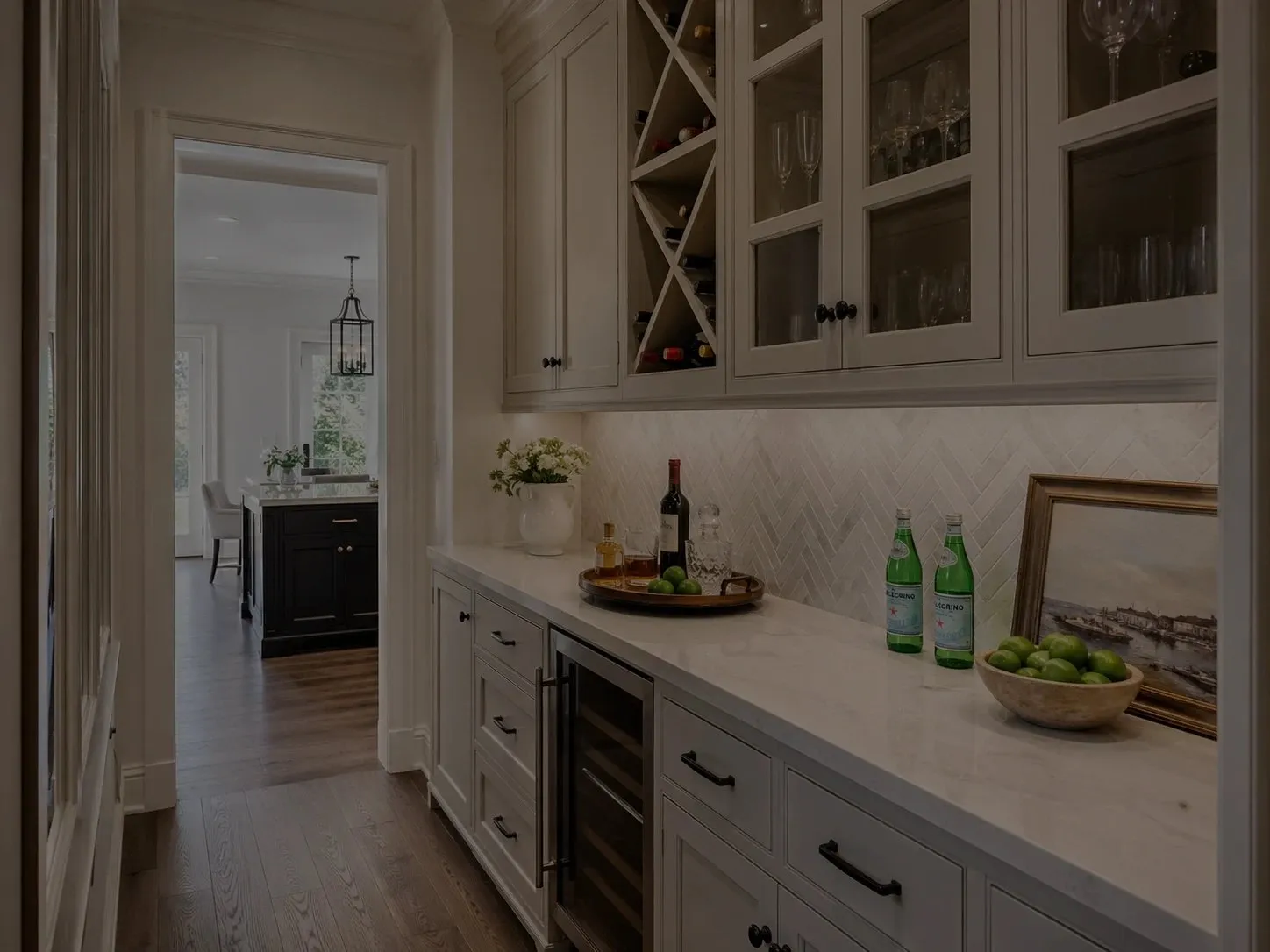 Butler's pantry cabinetry with glass uppers, wine storage and a beverage fridge