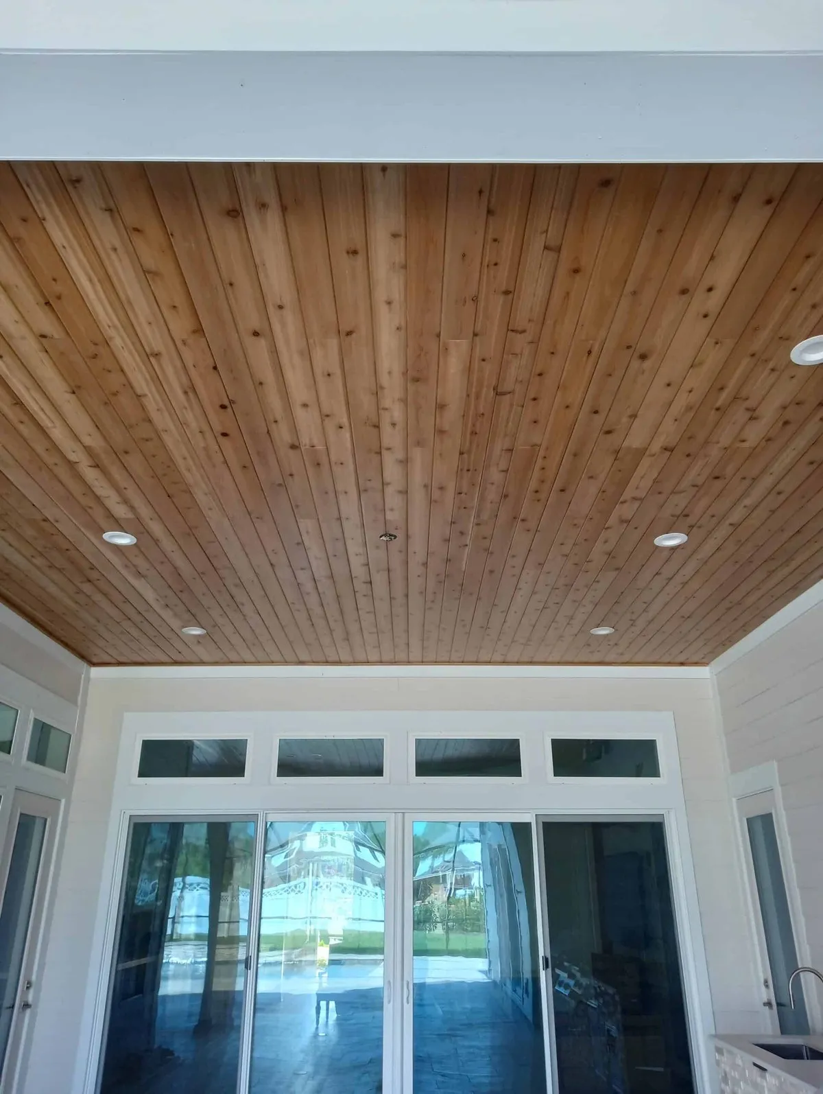 Tongue-and-groove wood plank ceiling above sliding glass doors